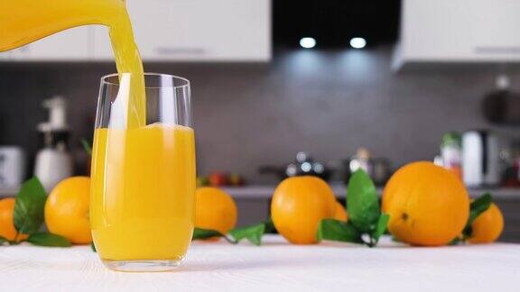 橙汁倒进白色桌子上的杯子里柑橘汁飞溅的慢动作
