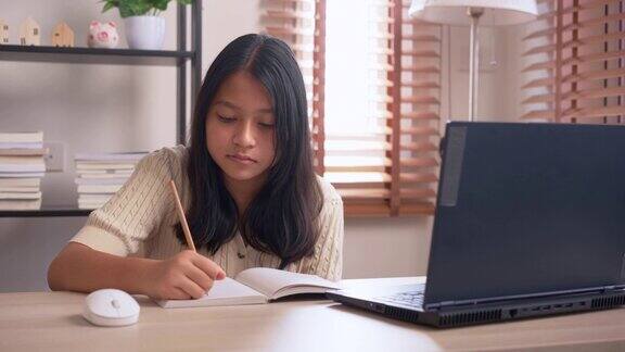 专心的女孩在家用笔记本电脑在线学习