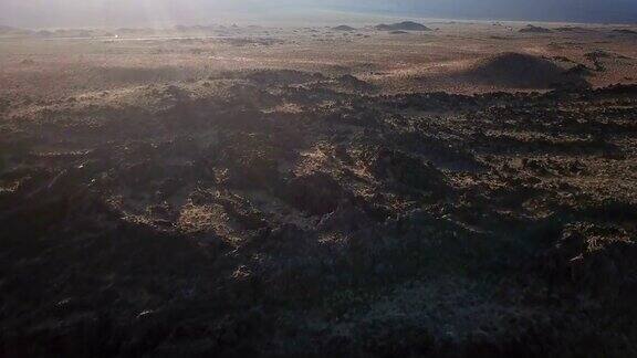 在加利福尼亚荒野日落时的火山岩石地形之上