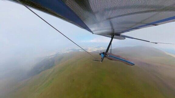 极限运动悬挂式滑翔机在山上飞过云层