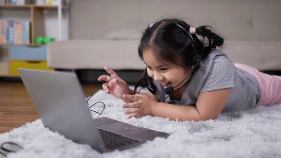 小女孩戴着耳机在客厅在线学习