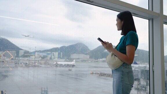 玩手机通讯在候机楼内等候登机的女子旅行
