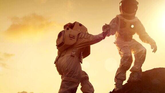 两名宇航员爬山互相帮助到达顶峰援助之手克服困难人类的重要时刻