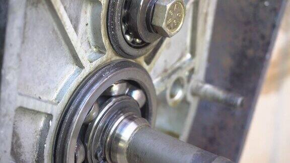 金属轴承旋转特写转动:汽车变速箱中轴承的转动老机械师在工作带轴承的铝曲轴箱