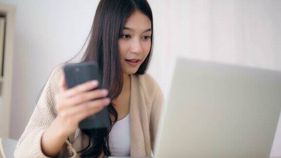 年轻的亚洲女性喜欢在家用笔记本电脑和智能手机打字聊天视频通话在线会议