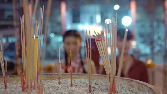 中国夫妇手持香烛在庙里祭拜