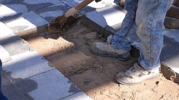 工人们正在清理沙质表面上的大块混凝土块