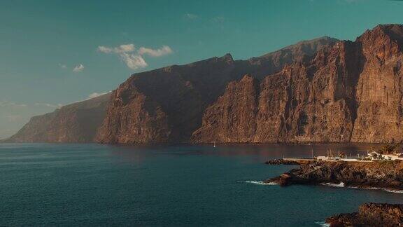西班牙加那利群岛特内里费岛洛斯吉甘特悬崖附近的平静海湾火山黑色岩石海滩日落时的海水景观