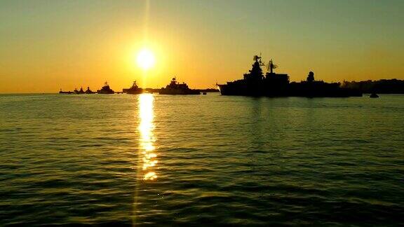 日落时海湾里战舰的剪影