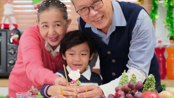 亚洲祖父母和小男孩在做饼干和面包店在圣诞节