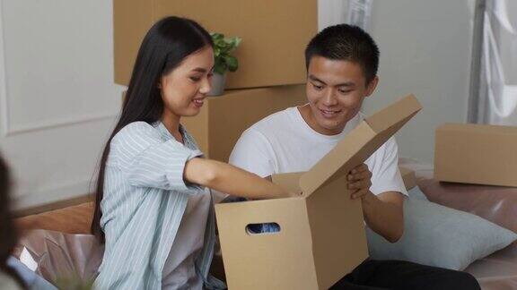 快乐的日本家庭收拾移动箱子坐在室内