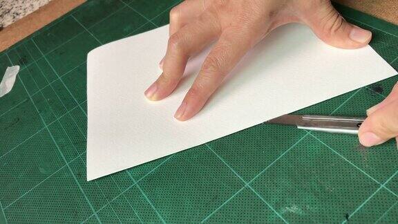 女人的手和切割机切割水彩纸
