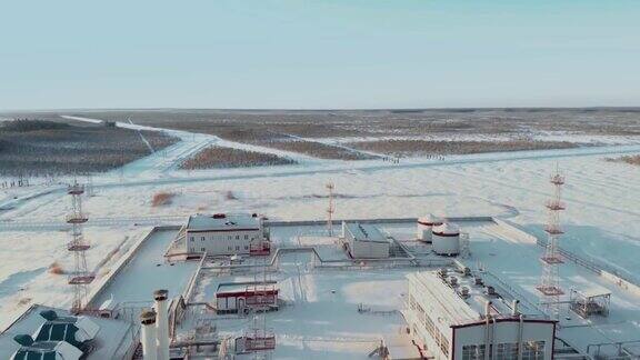 在大雪覆盖的西伯利亚上空飞过一座燃气轮机发电厂冬季油气田空中拍摄