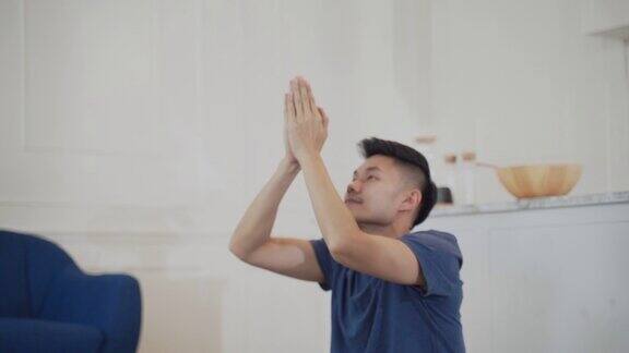亚洲男人在家里做莲花瑜伽姿势