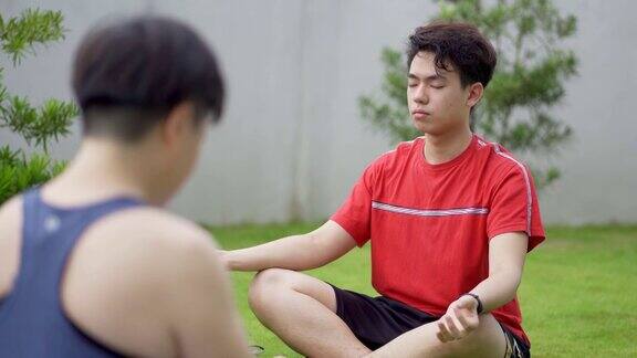一名亚洲华人男子和朋友在后院冥想