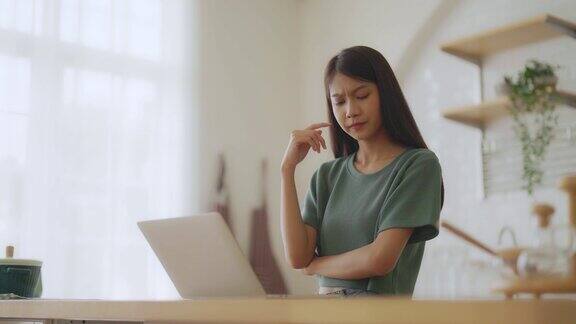 微笑的亚洲年轻女子工作在笔记本电脑在家里办公室年轻的亚洲学生使用电脑远程学习虚拟培训在线学习在家观看在线教育网络研讨会