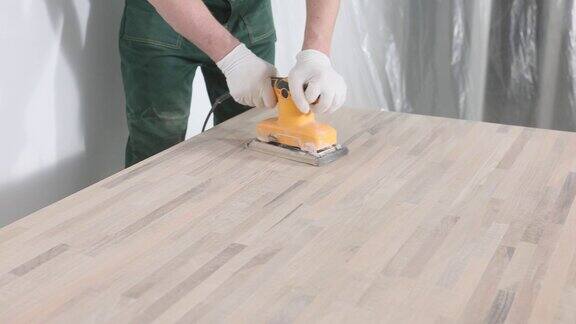 男员工用磨床打磨木桌