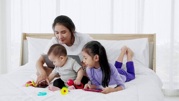 忙碌的单身妈妈在家工作还要照顾她的宝宝和小女儿