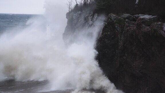 暴风雨的海浪以慢镜头撞击花岗岩海岸岩石峭壁