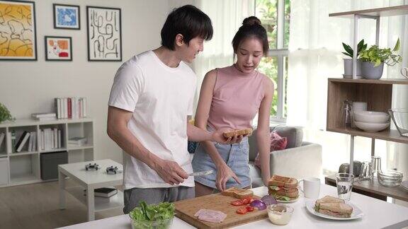 年轻的亚洲夫妇正在家里的厨房里做饭
