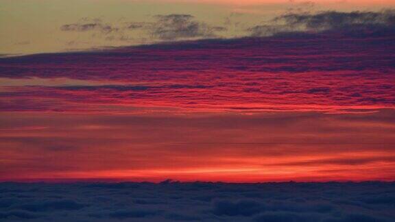 日落在多彩的多云的天空从山上