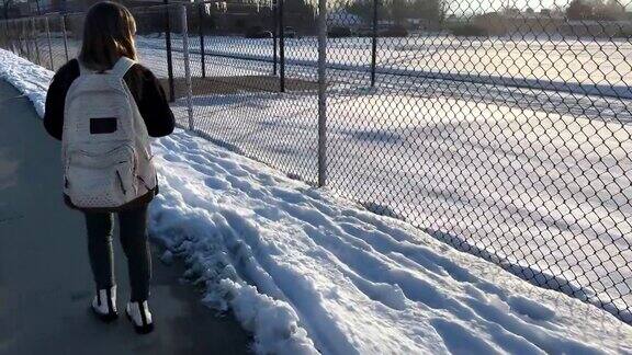 冬天一个小女孩独自走在上学的路上她回头一看
