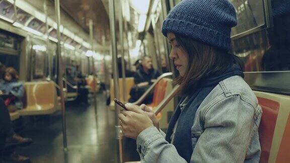 亚洲女性在地铁上使用智能手机