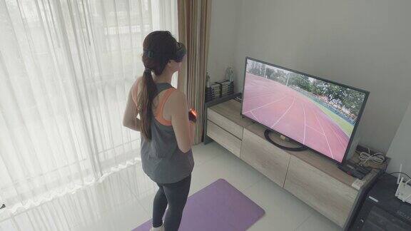 女性戴VR眼镜在虚拟跑道上跑步未来体育锻炼在线课堂在家里健身房与VR体验