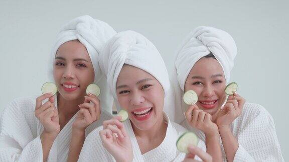 一群穿着浴袍的亚洲妇女用黄瓜护理眼睛