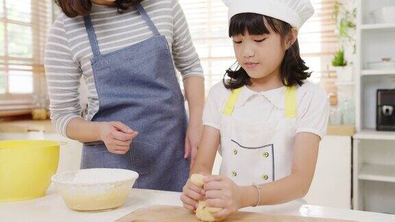 快乐微笑的年轻亚洲日本家庭与学龄前的孩子有乐趣在现代厨房家庭的早餐烘焙糕点或派