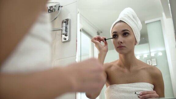 化妆在浴室涂睫毛膏的女人