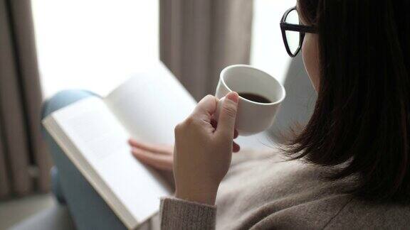 女人在放松的时候在家看书喝咖啡