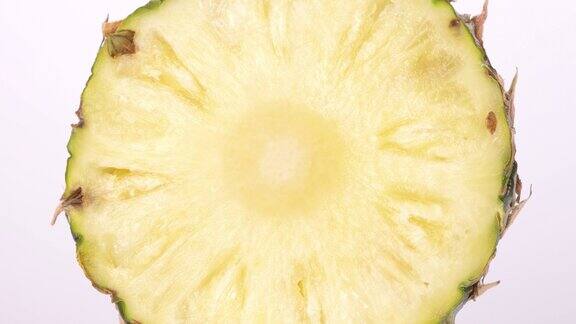 在桌子的白色背景上切成两半的菠萝