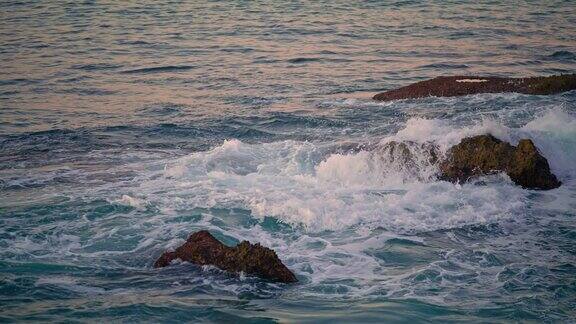 泡沫滚滚的海浪拍打着深色的岩石漩涡水令人惊叹的海洋景观