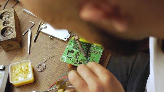 电子工程师焊接带有处理器的电路板修理电气设备从以上观点4k的视频