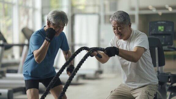 亚裔华人高级私人教练鼓励高级男子在健身房练习跳绳