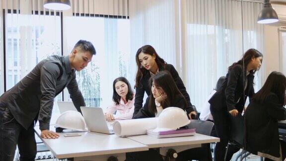 亚洲商人和工程师团队使用笔记本给商业伙伴讨论文件和想法商务女性在工作中微笑