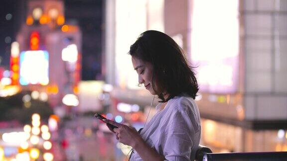成都一名年轻的亚洲女子在夜间使用手机