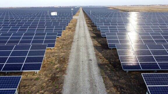太阳能电池板之间的土路太阳能发电站蓝色太阳能发电厂模块特写可替代的可再生清洁绿色能源环境生态能源自然发电技术