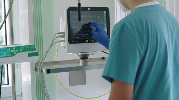 在医院病房里护士看着病人的生命体征监视器