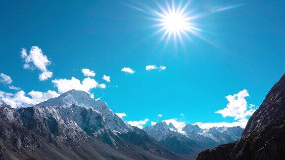 4K镜头的积雪覆盖印度喜马拉雅山脉与阳光灿烂的太阳之星在晴朗的蓝色冬季天空山的风景印度喜马偕尔邦斯皮提山谷的雪山