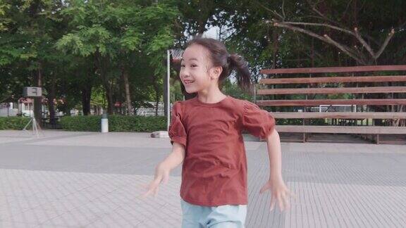 脸聚焦4K可爱的亚洲女孩谁是快乐地跑在学校操场上玩追逐和捕捉显示户外活动的童年在夏天的快乐和乐趣