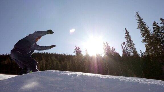 一名男子在一个阳光明媚的日子里单板滑雪