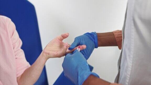手指血液测试手戴手套采集血样的特写血液检测的特写护士从男性手上抽血医学测试艾滋病毒护士用试管采血