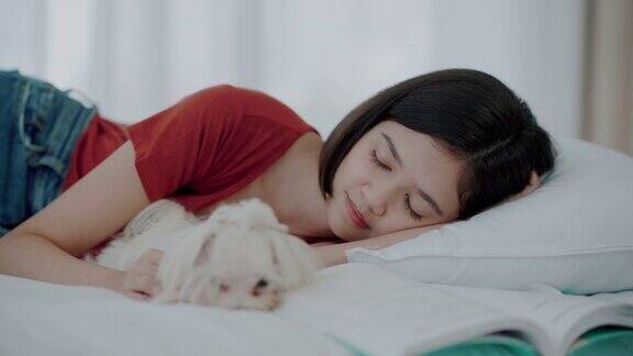 一个亚洲女人和一只狗在家里睡觉