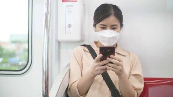 年轻女子在火车上用手机和短信