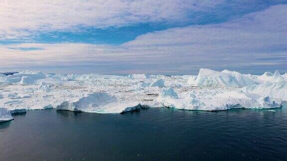 北极景观蓝绿色的海湾融化了冰山巨大的冰川在极地自然环境北极冬季景观在全球变暖问题无人机拍下了沙漠白色的冰雪大地