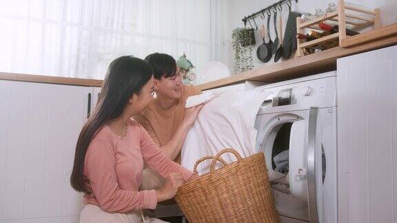 快乐的亚洲年轻夫妇在家里一起洗衣服