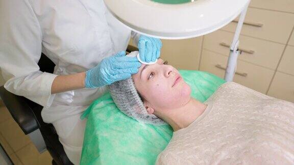美容师准备女人的脸之前皮肤护理美容程序在诊所