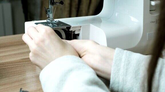 特写女性的手拆卸缝纫机用刷子清除灰尘